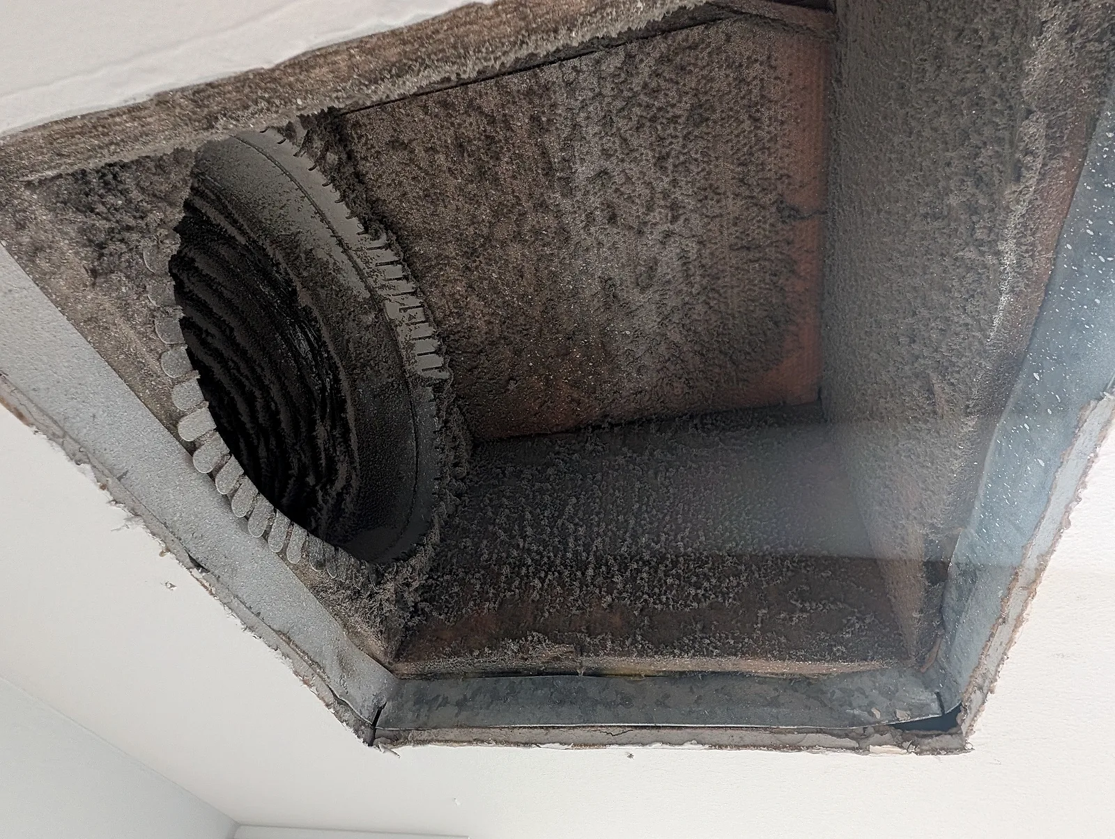 Inspection photo: dusty interior of a ceiling air register boot