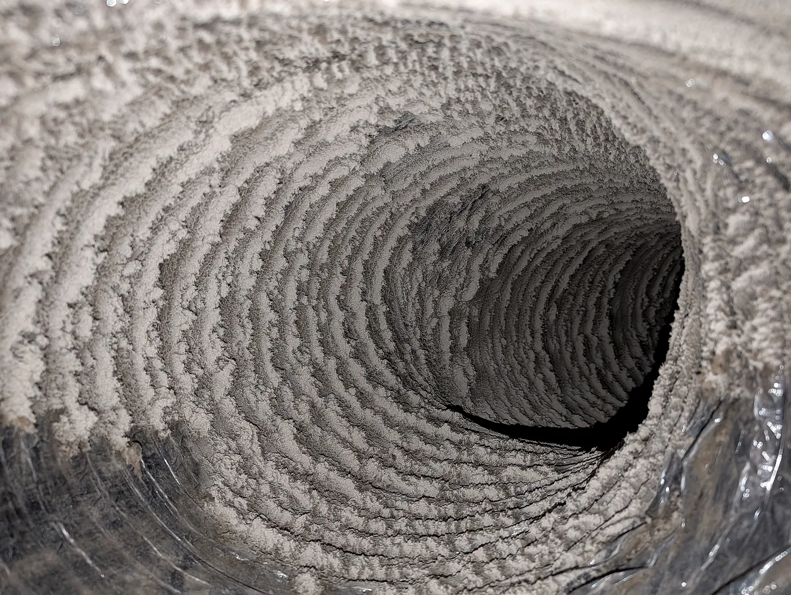 Before cleaning: flexible dryer vent interior heavily coated with dust and lint